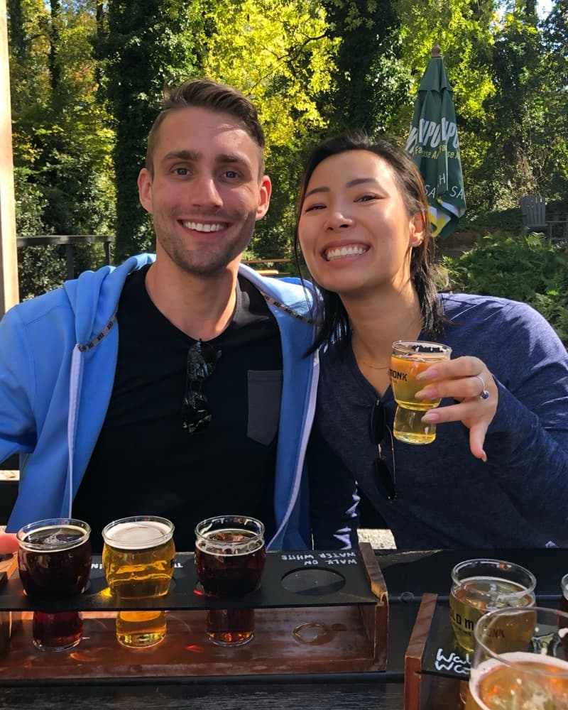 Matt and Anna on the patio at Bold Monk Brewing, behind two flights of beer.