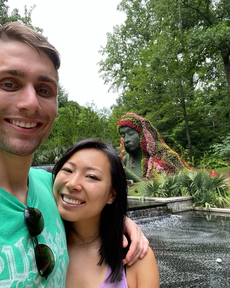 A selfie of Matt and Anna at the Atlanta Botanical Garden, a giant plant sculpture behind them.