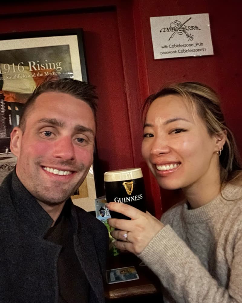 Anna and Matt at The Cobblestone pub in Dublin, Anna holding a pint of Guinness, her ring showing.