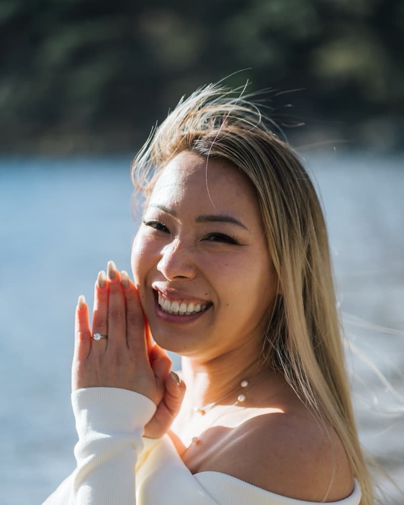 Anna, hands to her face, laughing, with the ring on.