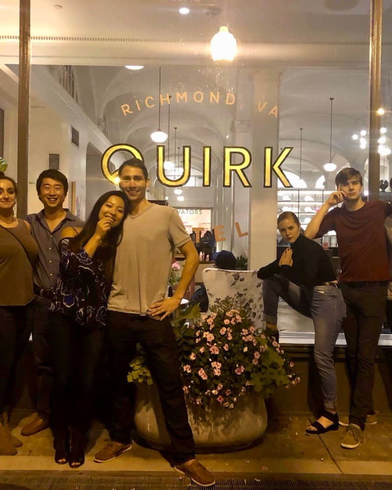 Anna and Matt with friends outside the Quirk Hotel in Richmond at night, under its gold sign.